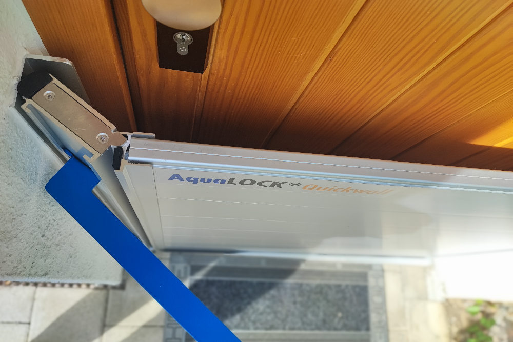 AquaLOCK® Quickwall Hochwasserschutzsystem mit seitlicher Aluminiumhalterung an einer Außentür