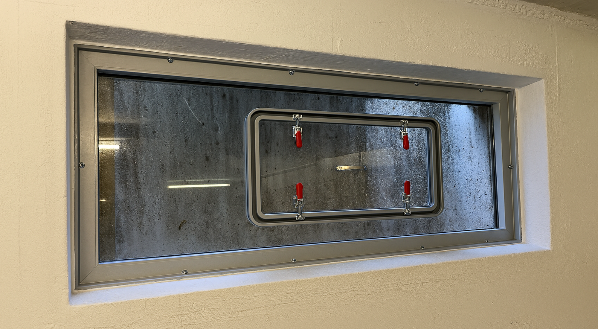 AquaLOCK® Hochwasserschutzfenster mit montiertem Schutzrahmen und roten Spannverschlüssen