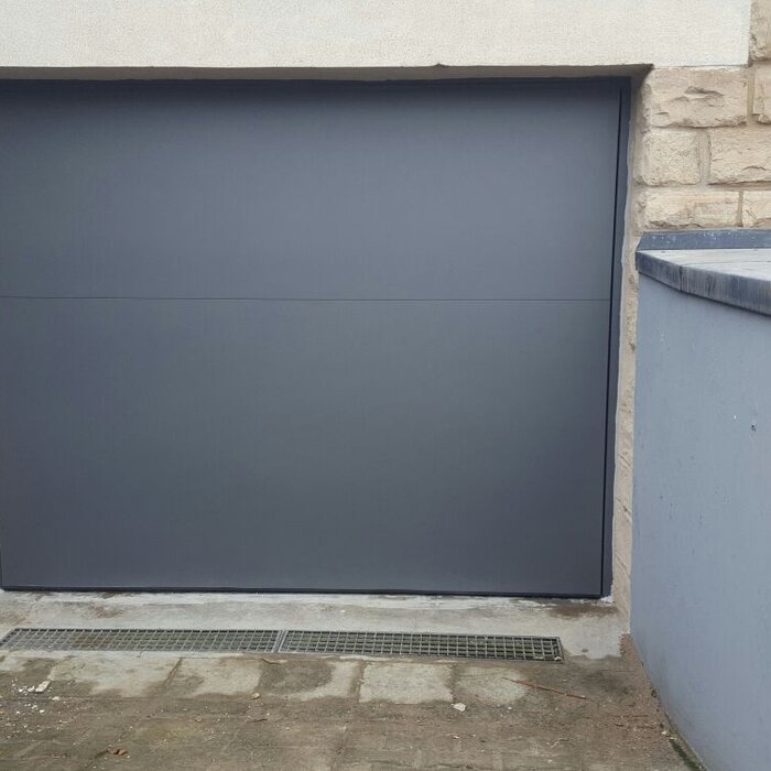 Geschlossenes graues Schwingtor mit Bodendichtung als Hochwasserschutz