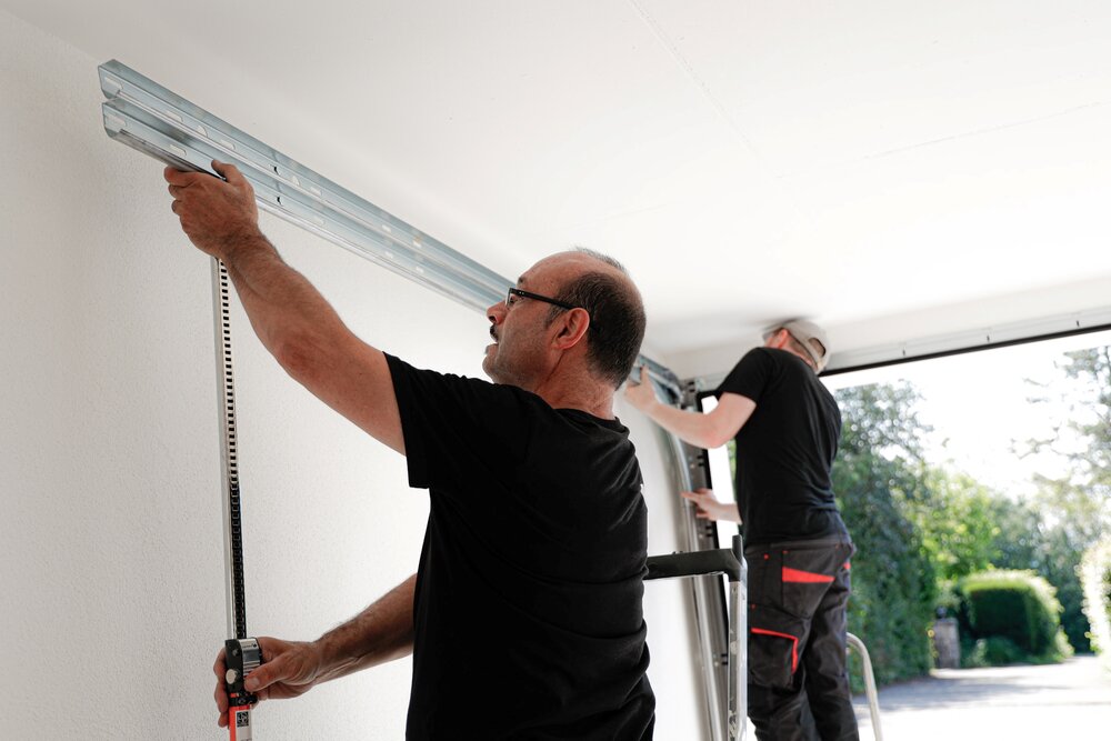 Installation eines Garagentores durch Montagearbeiter